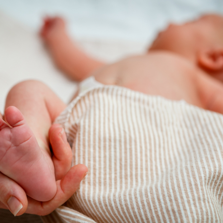 Newborn Screening Program hand holding infant heel