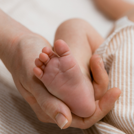 Hand holding infant foot