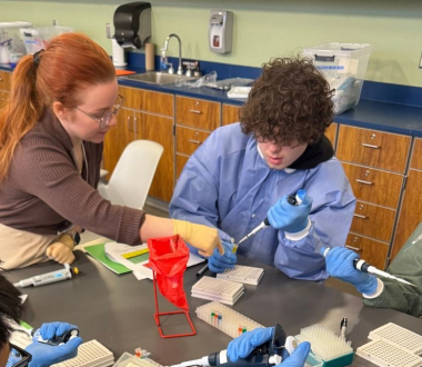 Stephanie demonstrating how to use a pipette at RiseHigh